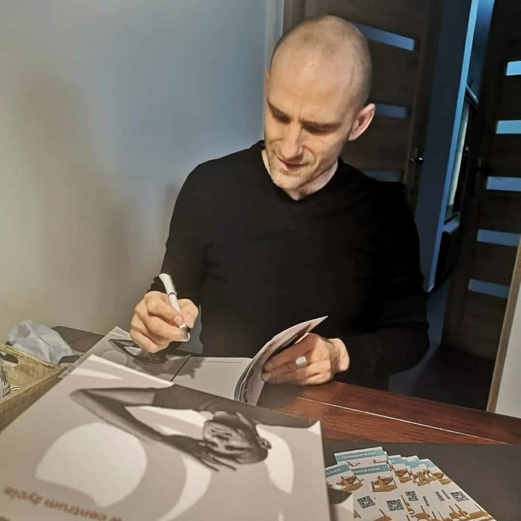 Mariusz Kurc podpisuje książki w biurze Wydawnictwa KAdruk